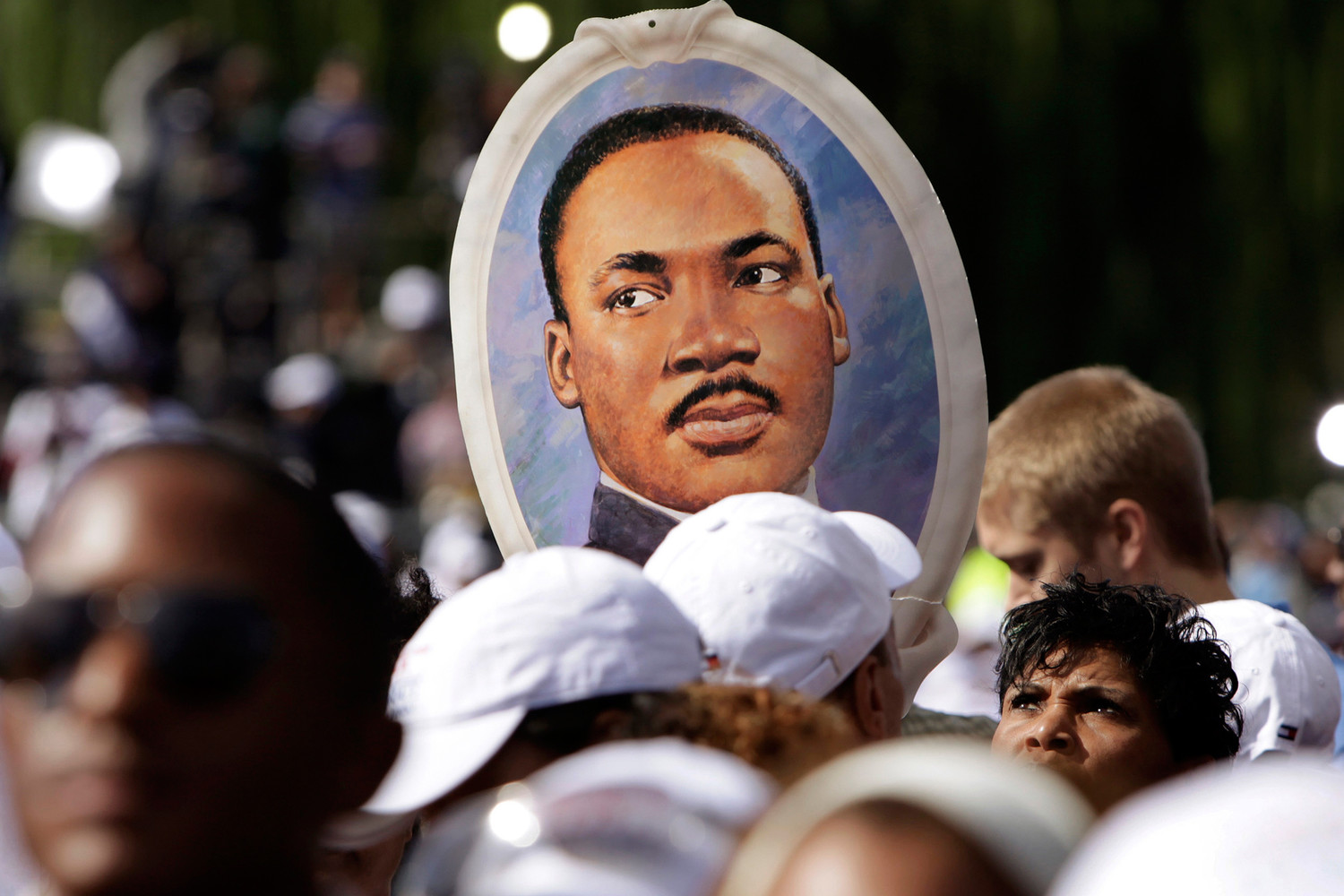A woman holds a portrait of the Rev. Dr. Martin Luther King Jr. during the 2011 dedication of the King memorial at the National Mall in Washington. Fifty years after the assassination of the civil rights leader, “we need to ask ourselves if we are doing all we can to build the culture of love, respect and peace to which the Gospel calls us,” the U.S. Catholic bishops’ Administrative Committee said March 28.